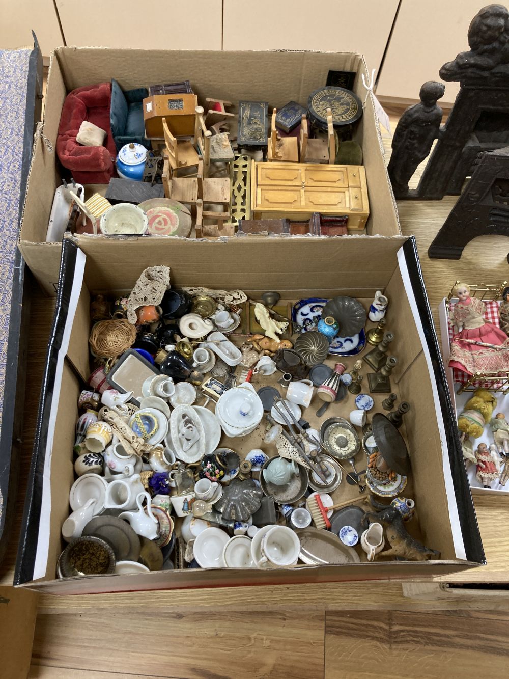 A collection of dolls and dolls house furniture displayed in room settings in a pine cupboard, width 84cm, depth 36cm, height 132cm